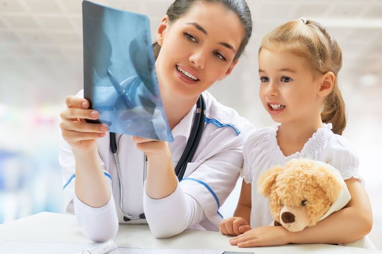 Bild Ärztin zeigt einem Kind ein Röntgenbild